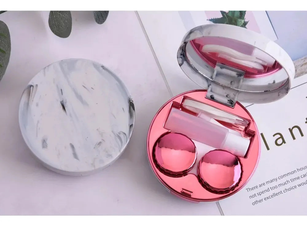 Estuche de mármol color fucsia abierto junto a su tapa de mármol blanco